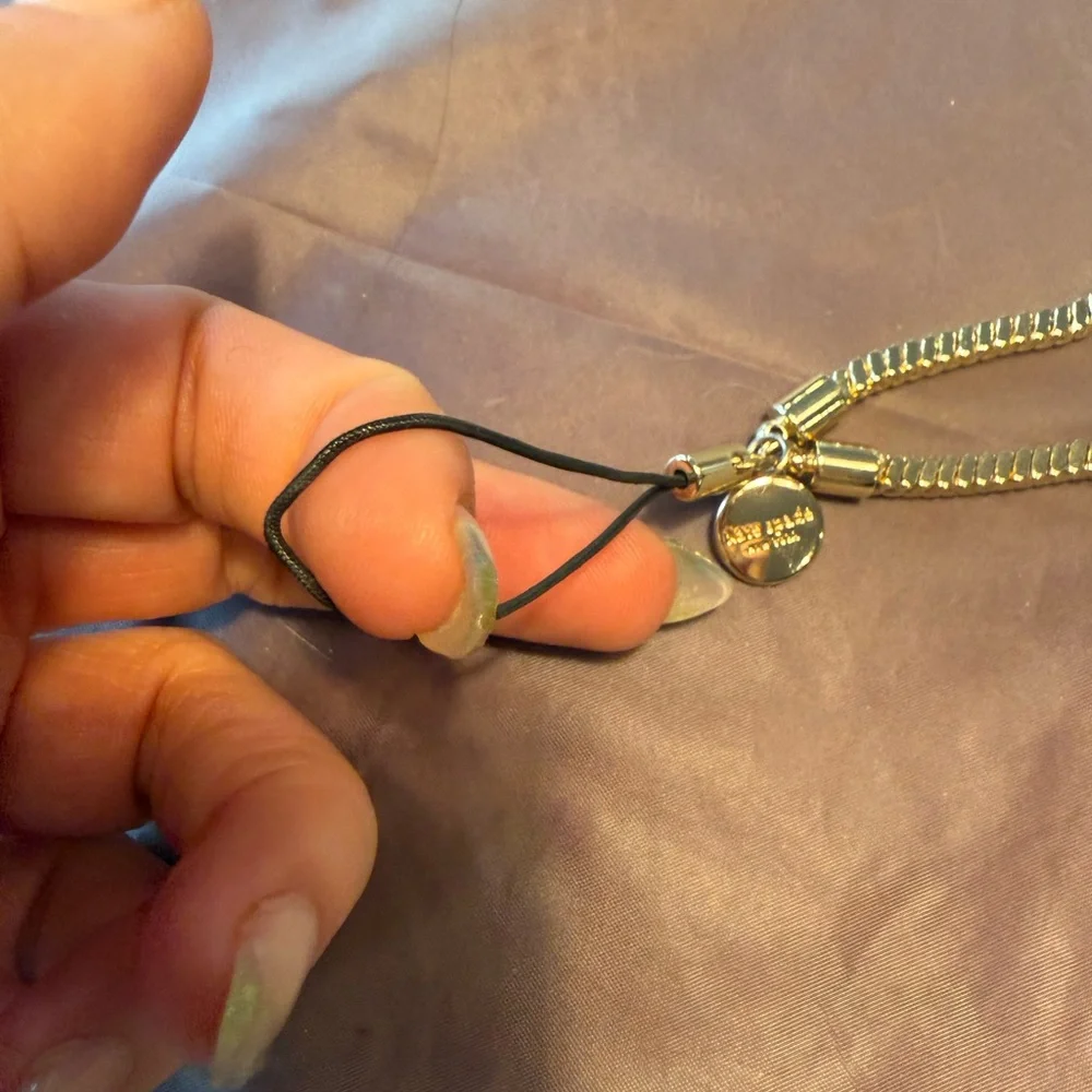kate spade Gold Tone Phone Wrist Strap with Black Cord Loop